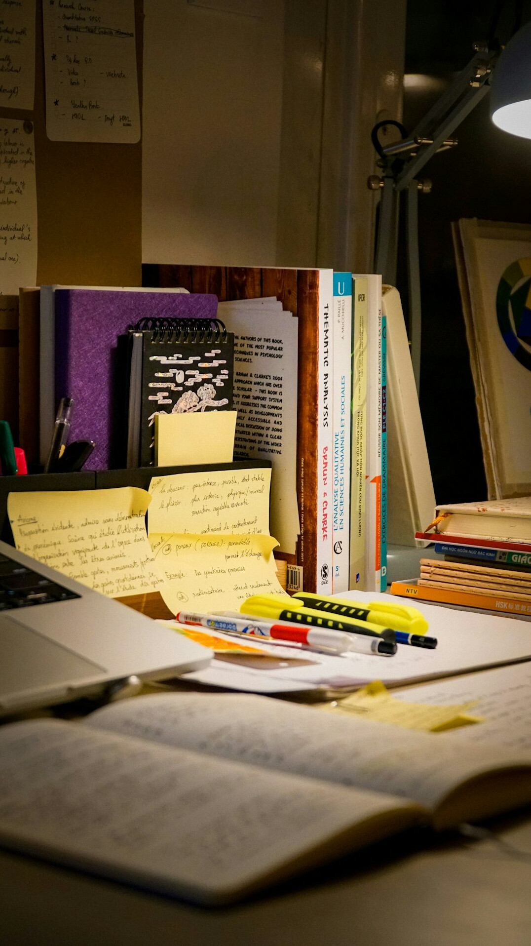 Desk with laptop, notes and charts being reviewed